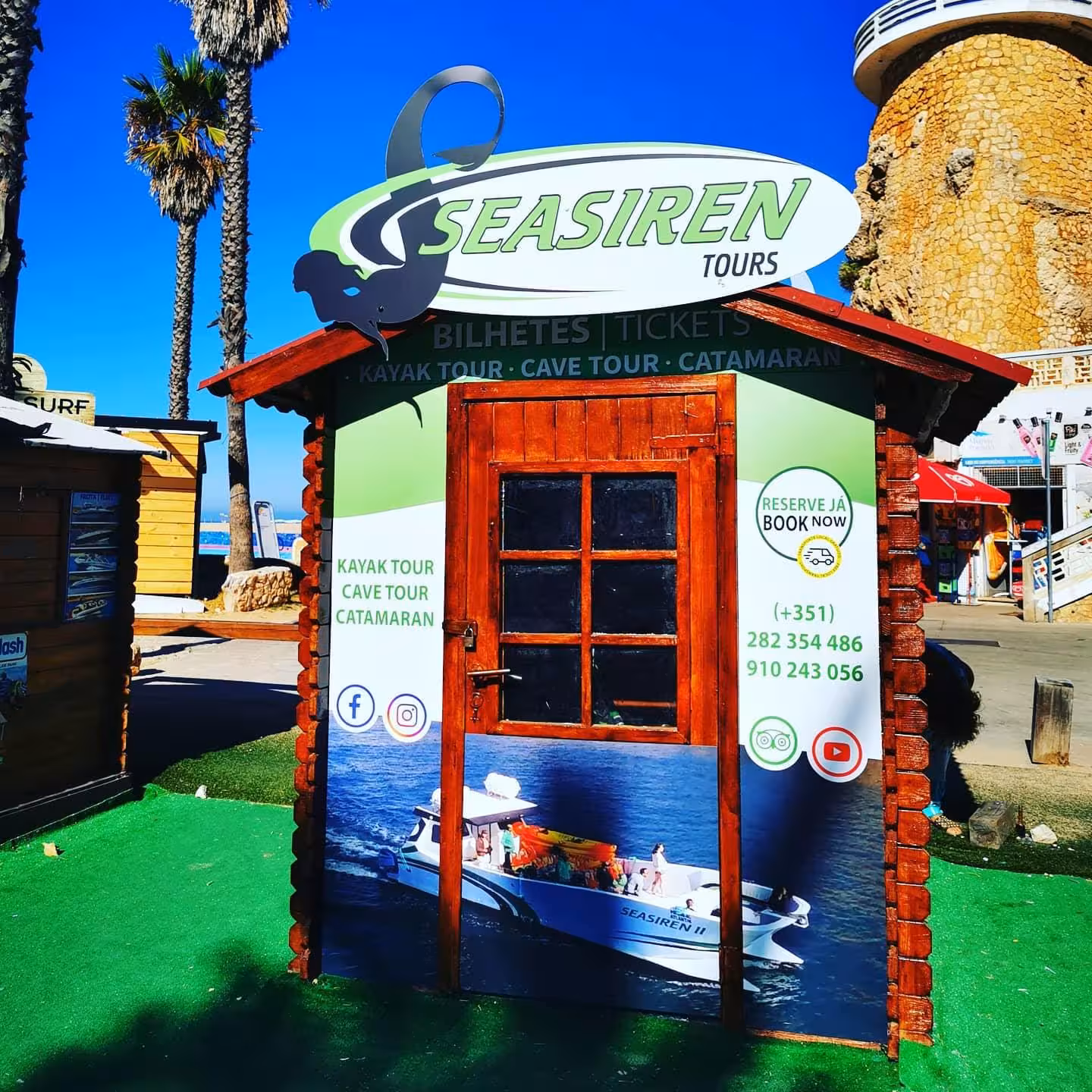 SeaSiren Tours wooden kiosk by the beach promoting private kayak tour, cave tour and catamaran trips in Algarve, Portugal