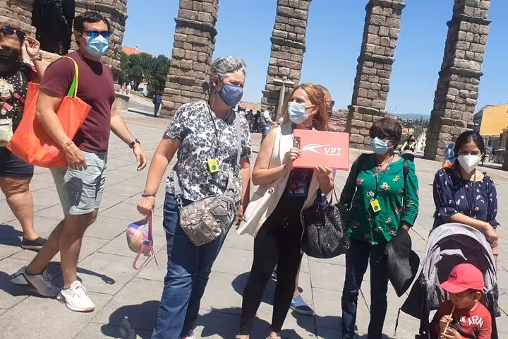 Visitors enjoying a guided tour at the iconic Segovia aqueduct, a highlight of the Madrid day trip.