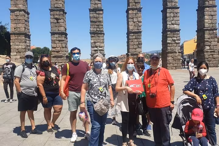 Tour group exploring the historic Roman aqueduct in Segovia during a guided tour from Madrid.
