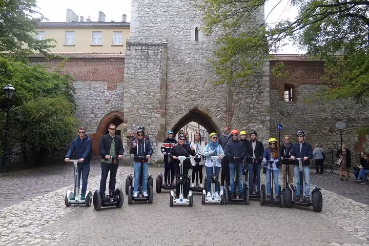 Group of tourists on a Segway tour exploring historic landmarks in Krakow's Old Town for 120 minutes.