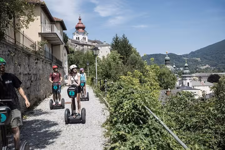 Tourists enjoying a scenic Segway ride along a cobblestone path with views of Salzburg's historic architecture.