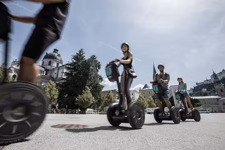 Tourists enjoy a scenic Segway ride near Salzburg Cathedral during the Salzburg City and Mountain Tour.
