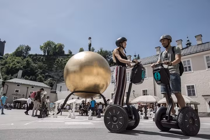 Riders enjoy a Segway tour near Salzburg's iconic golden sphere, a unique city sightseeing experience.