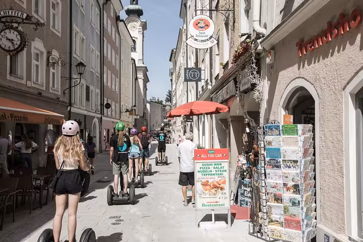 Segway riders explore Salzburg's charming old town streets lined with shops and vibrant local cafes.
