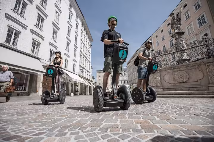 Tourists on Segways exploring Salzburg's charming cobblestone streets.