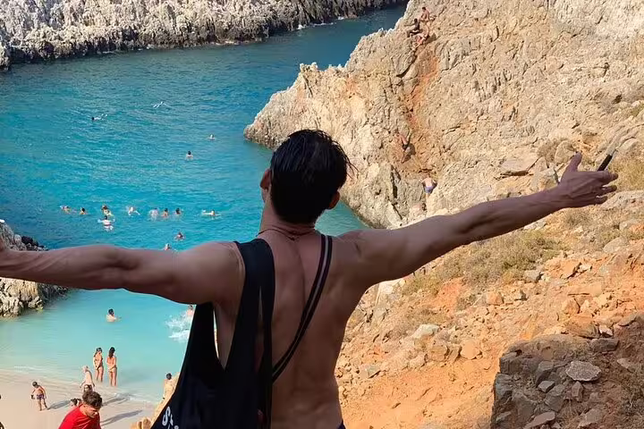 Visitor enjoying panoramic views of Seitan Limania Beach, Crete, surrounded by stunning cliffs and turquoise waters.