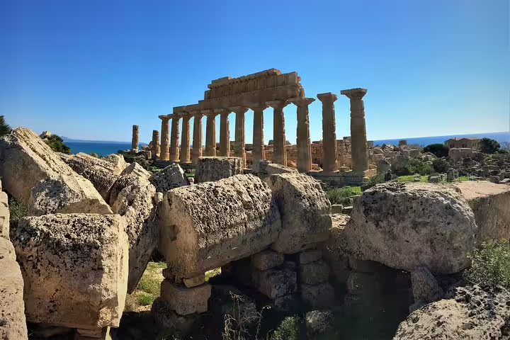 Panoramic view of Selinunte archaeological park with massive fallen temple columns and sea backdrop on a Sicily private tour
