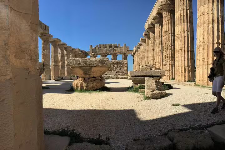 Interior courtyard of Tempio E at Selinunte with massive stone columns and altars seen on a guided private tour from Palermo