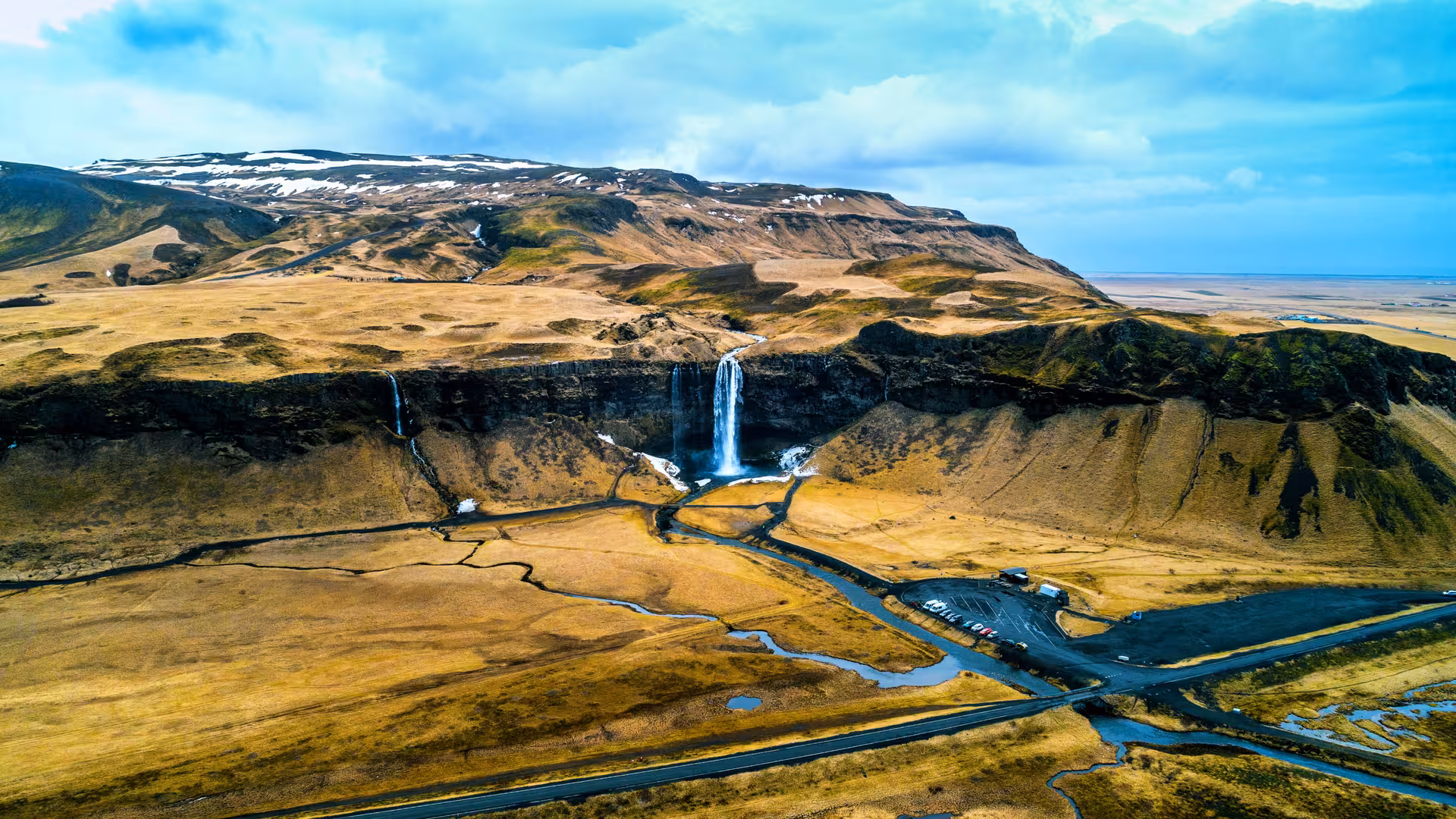 Aerial view of Seljalandsfoss waterfall and surrounding landscapes on the Golden Circle Tour in Iceland.