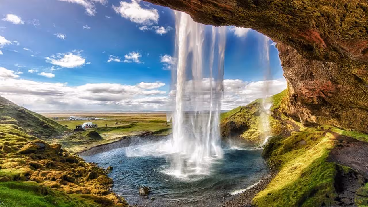 Seljalandsfoss waterfall view from behind on Iceland Golden Circle and South Coast tour, mossy cliffs