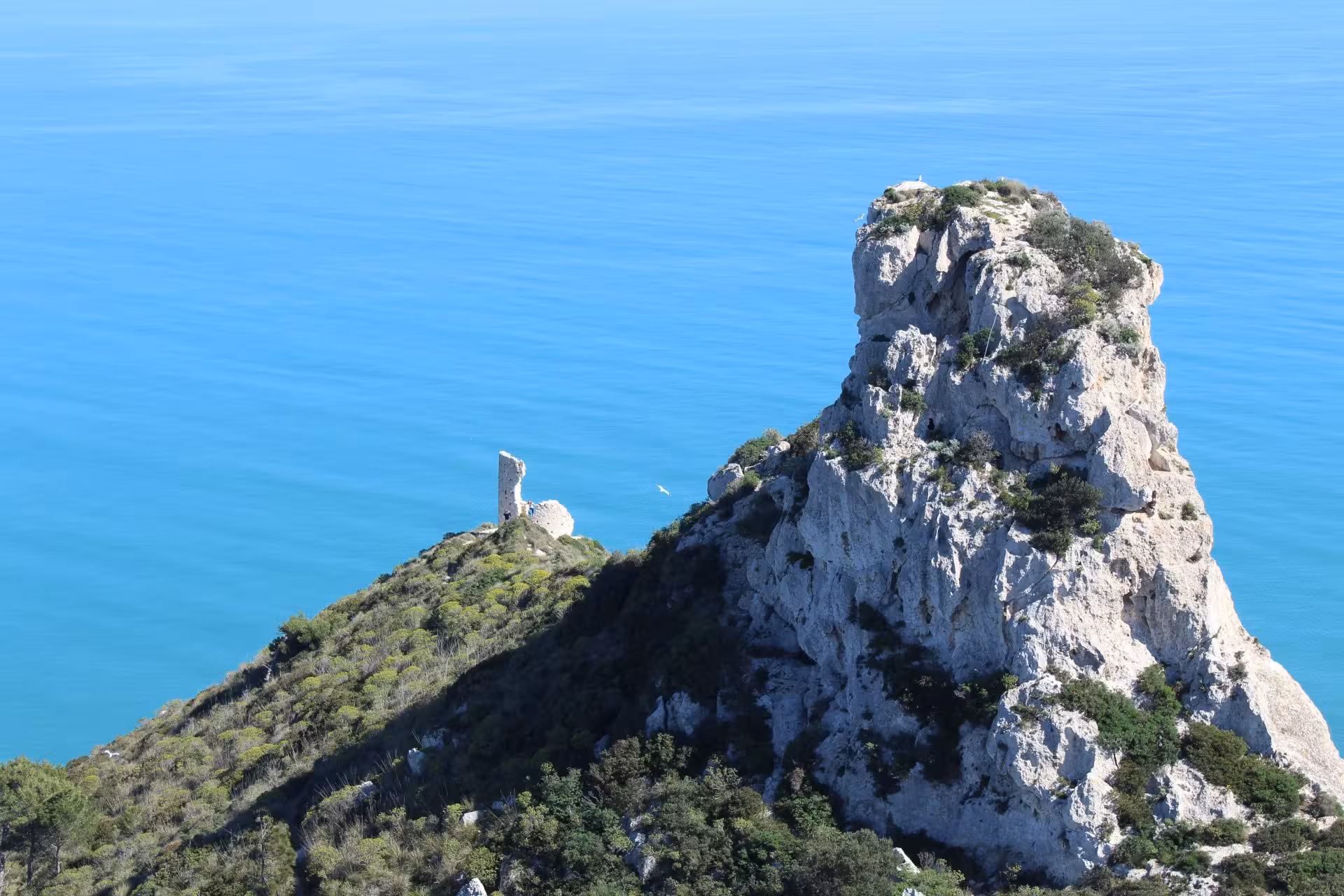 A stunning view of Sella del Diavolo's rocky cliffs overlooking the turquoise Mediterranean Sea in Cagliari.
