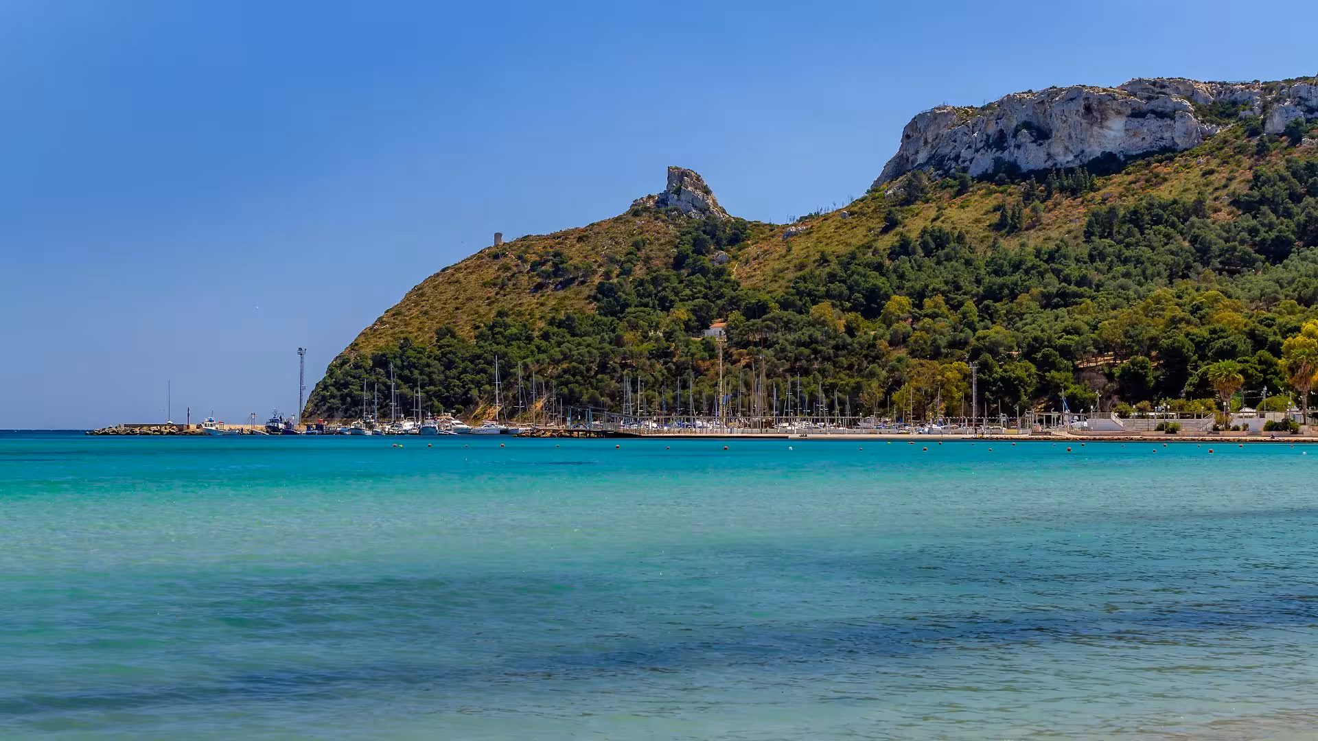 Breathtaking view of Sella del Diavolo with turquoise waters and lush greenery, ideal for trekking in Cagliari.