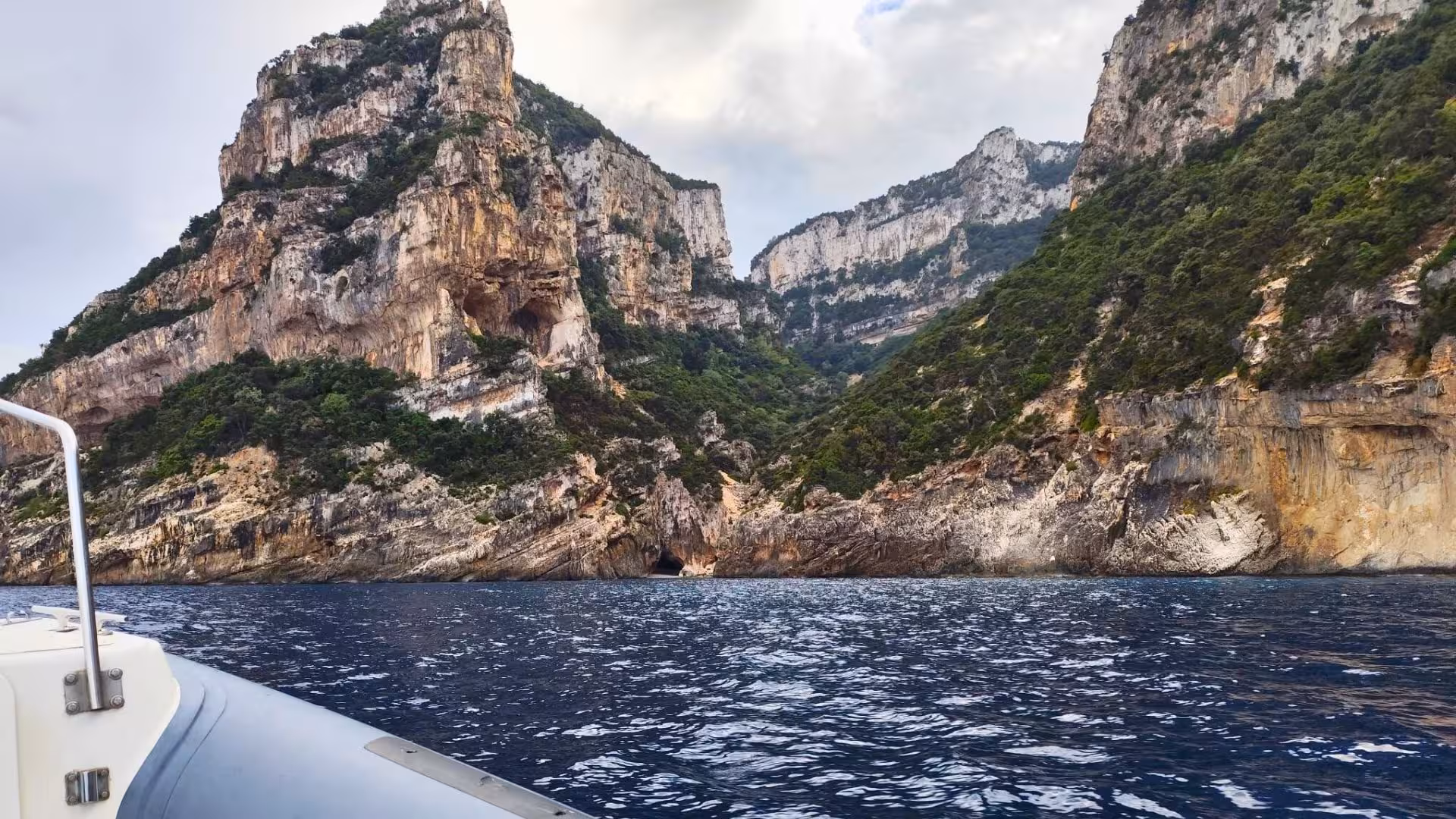 Boat view of dramatic cliffs and lush greenery on the Selvaggio Blu trek from Arbatax.