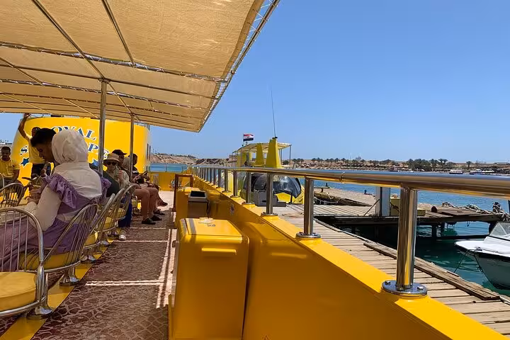 Passengers seated on yellow semi submarine deck at Sharm El-Sheikh marina before Red Sea underwater tour transfer