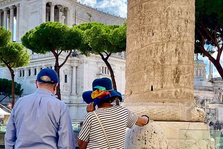 Senior couple on a private guided Rome VIP tour admiring sculpted Trajan’s Column near Piazza Venezia and historic monuments