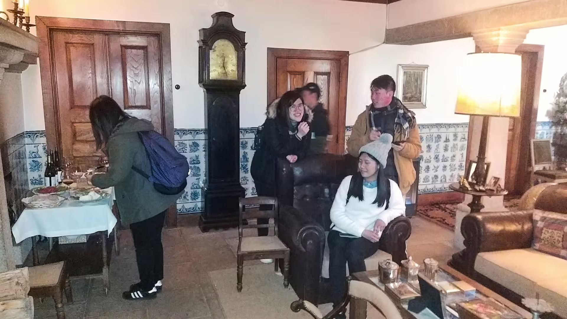 Visitors enjoy a cozy tasting experience in Serra da Estrela, sampling local cheese and wine in a charming rustic setting.