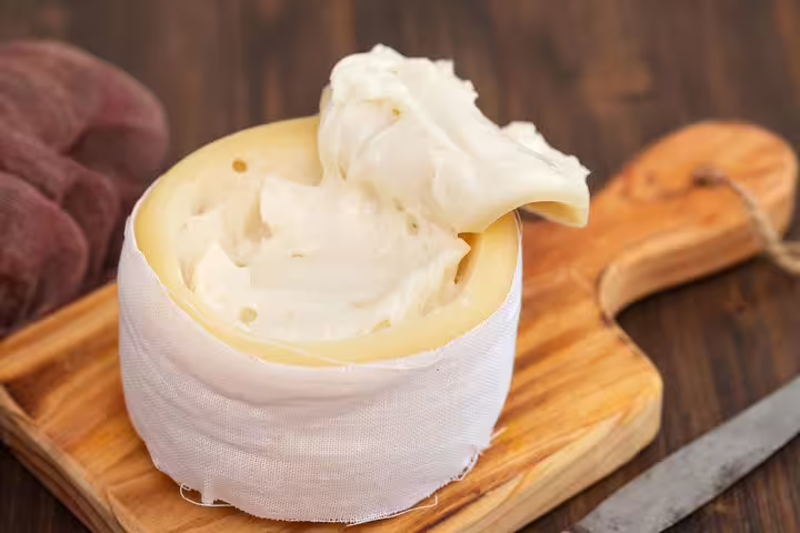 Creamy Serra da Estrela cheese on a wooden board, a must-try delight during the full-day private tour.