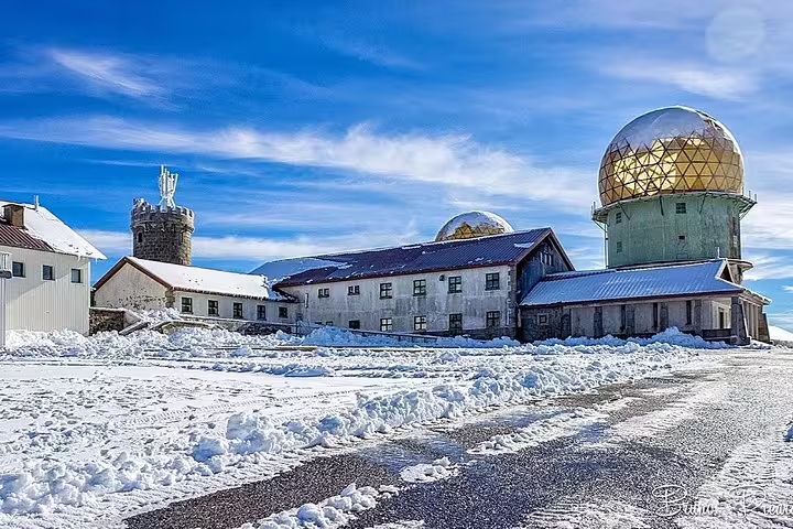 Serra da Estrela Private Tour from Lisbon showcases snowy mountain landscapes and iconic observatories under clear blue skies.