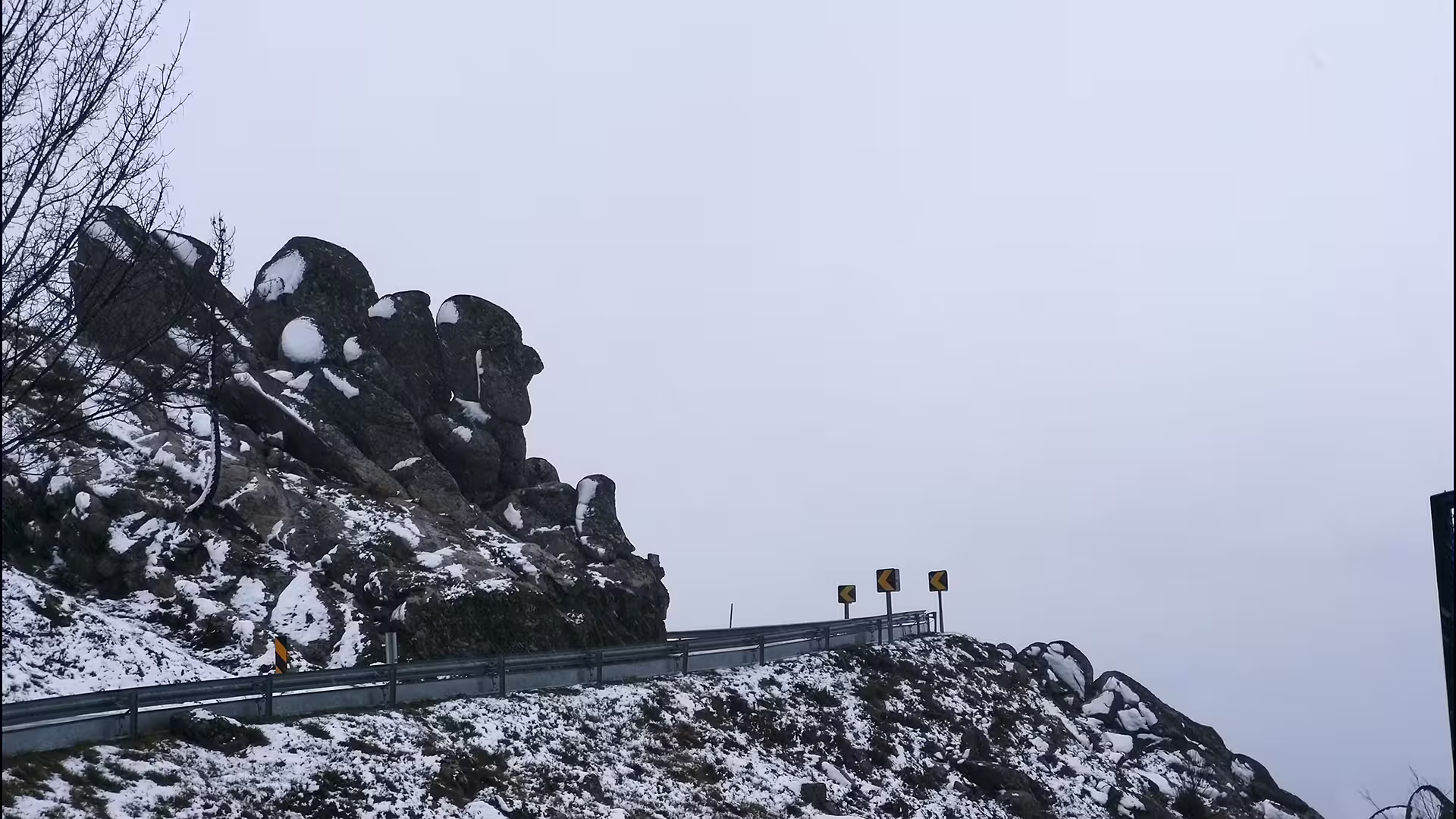Scenic winter view of snow-covered rocky cliffs in Serra da Estrela Park, ideal for private tours and cheese tasting experiences.