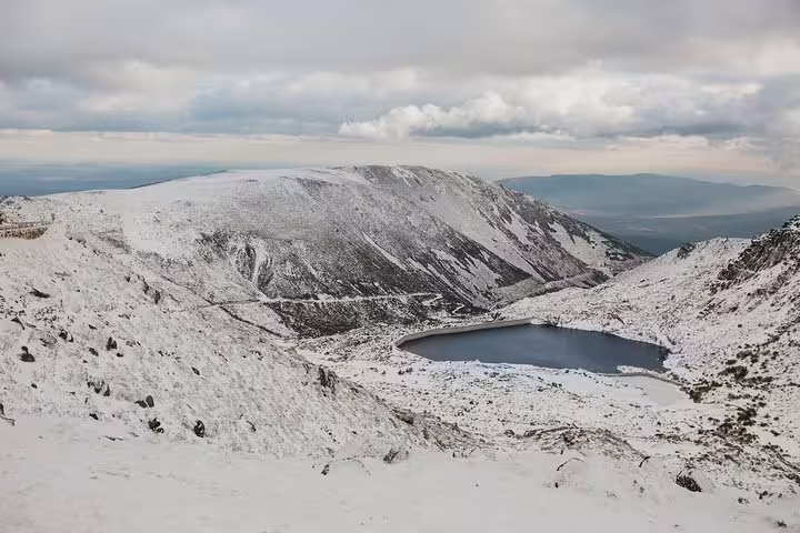 Snow-covered Serra da Estrela landscape with scenic views and a tranquil lake, ideal for a private tour from Lisbon.