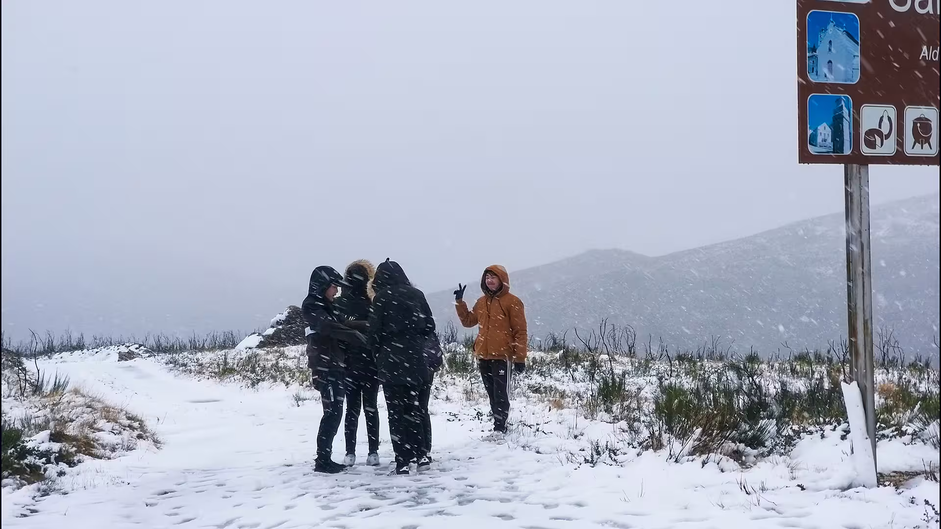 Visitors enjoy a snowy landscape during a Serra da Estrela Park private tour, famous for its scenic views and unique cheese.
