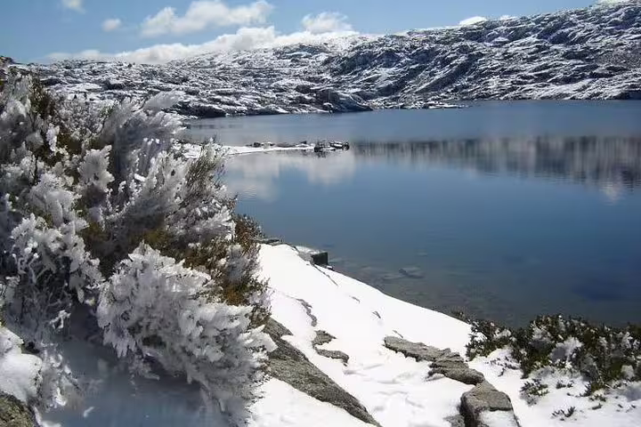 Serra da Estrela's snowy landscape and serene lake, ideal for a scenic private tour in Portugal's highest mountains.