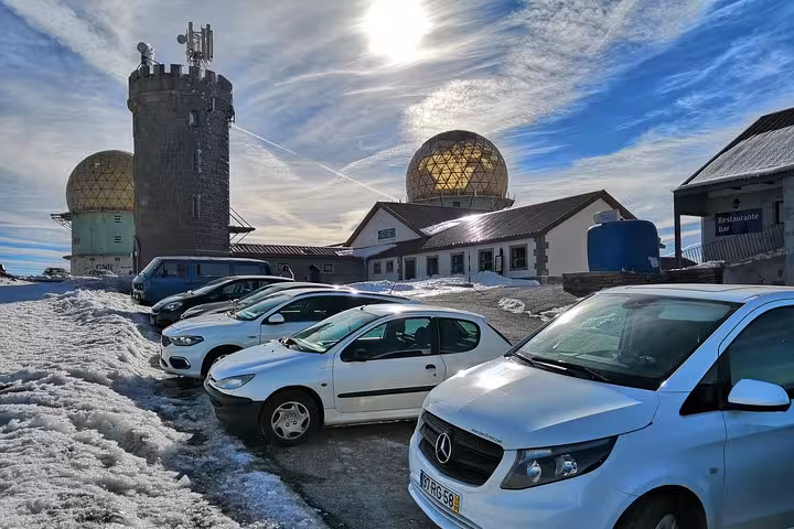 Snowy Serra da Estrela plateau with parked cars near radar dome, winter Portugal Snow day trip scenery