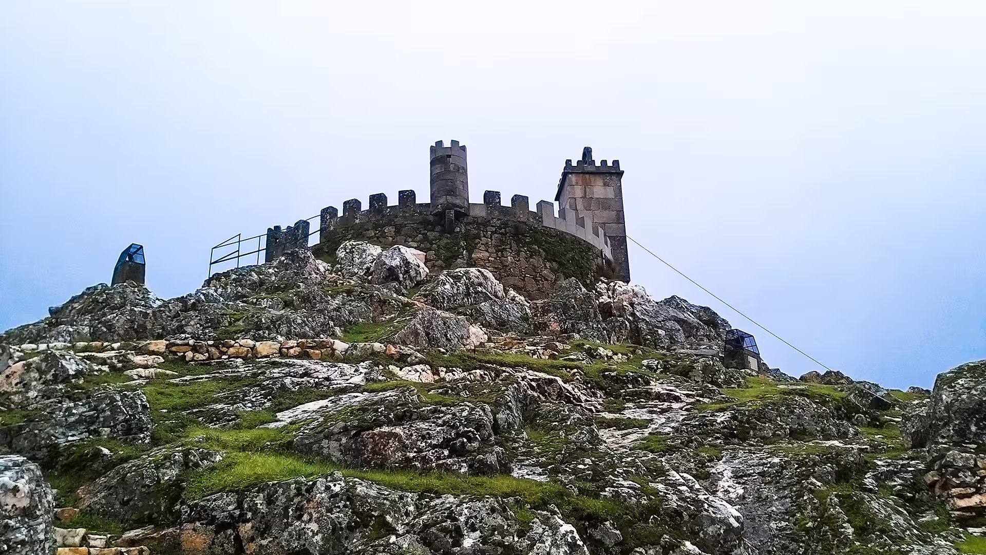 Ancient stone fortress atop rocky hill in Serra da Estrela Park, ideal for exploring history and tasting local cheese.