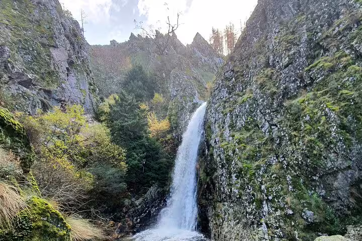 Majestic waterfall cascading down moss-covered rocks in the serene landscape of Serra da Estrela.