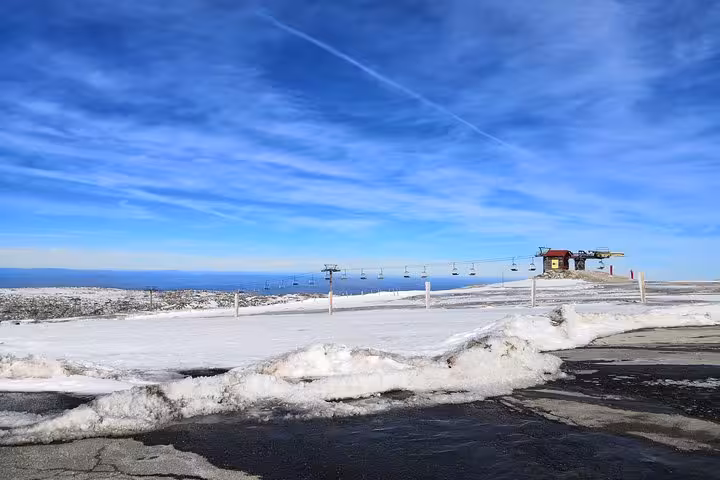 Serra da Estrela ski area chairlift and snowy plateau under blue sky on Portugal Snow day trip