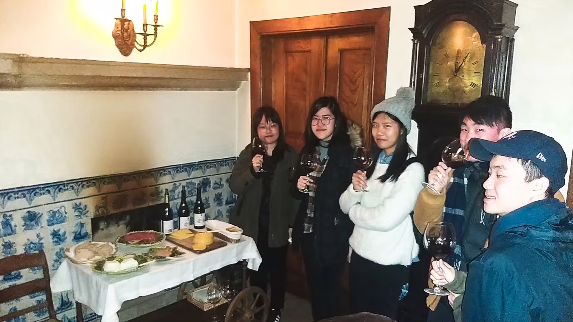 Group enjoying wine and traditional cheese tasting inside a cozy room during Serra da Estrela Park private tour experience.