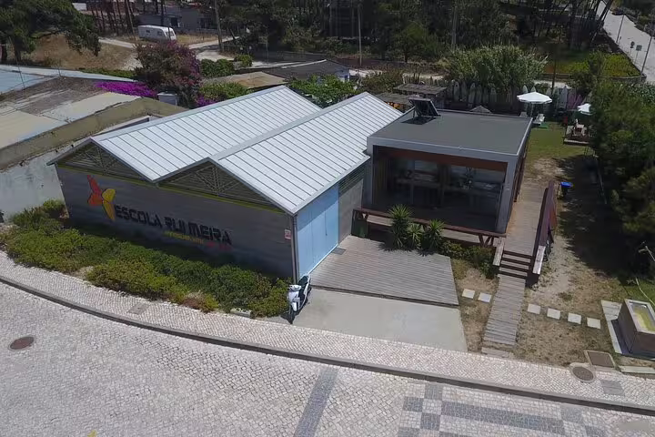 Aerial view of Escola do Mar in Sesimbra, Portugal, offering easy kayak experiences amidst scenic lagoon landscapes and lush greenery.