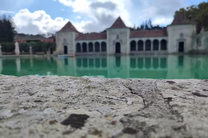 Scenic view of a tranquil pond and historic architecture in Setúbal, perfect backdrop for a Moscatel wine tour.