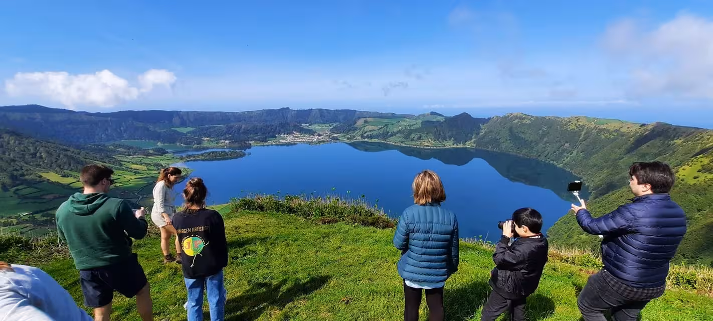 Small group admiring panoramic view over Sete Cidades crater lake on São Miguel island during full‑day van tour