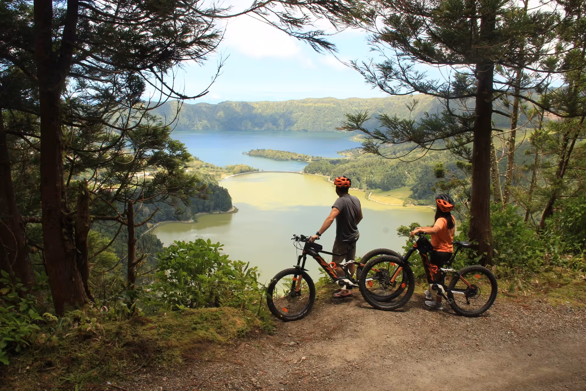 Cyclists on a forest trail overlooking Sete Cidades twin lakes, enjoying the Seven Cities Experience adventure tour in the Azores