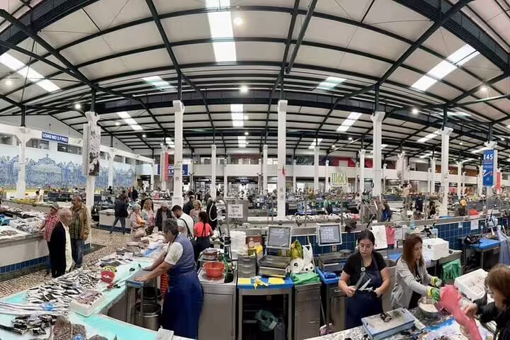 Bustling Setúbal market with local vendors showcasing fresh seafood, a highlight of the Arrábida wine and food tour from Lisbon.