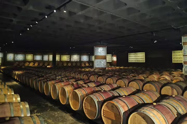 Extensive wine cellar filled with barrels, highlighting the traditional aging process of Setúbal Moscatel wines.