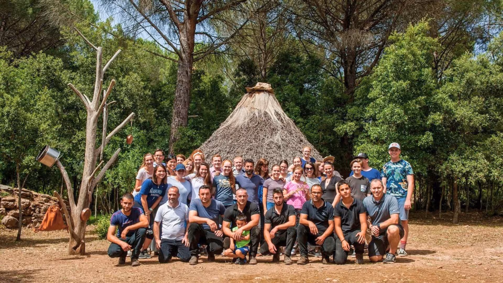 Group of visitors gathered in front of a traditional hut during Seulo farm tour, highlighting cultural immersion in Sardinia.
