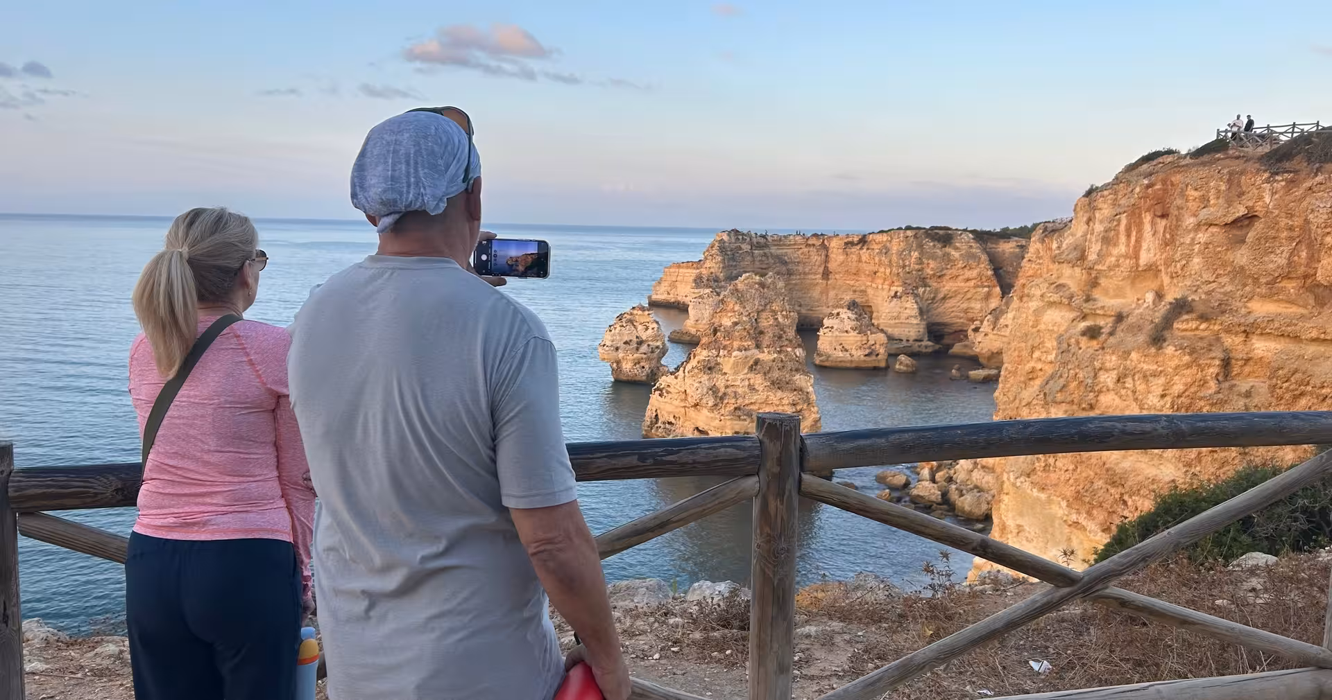 Tourists photographing stunning golden cliffs and sea stacks on the Seven Hanging Valleys guided tour in Algarve Portugal