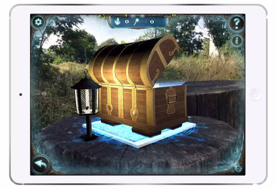 Tablet displaying a virtual treasure chest and lantern in a nature setting for Sevilla outdoor escape game for kids.