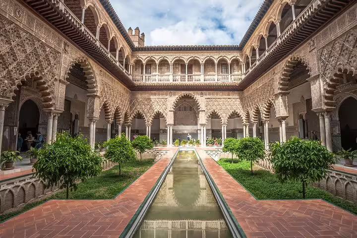 Stunning view of the intricate Moorish architecture and lush gardens of the Alcazar of Seville, featured in our exclusive skip-the-line tour from Cadiz port for cruisers.