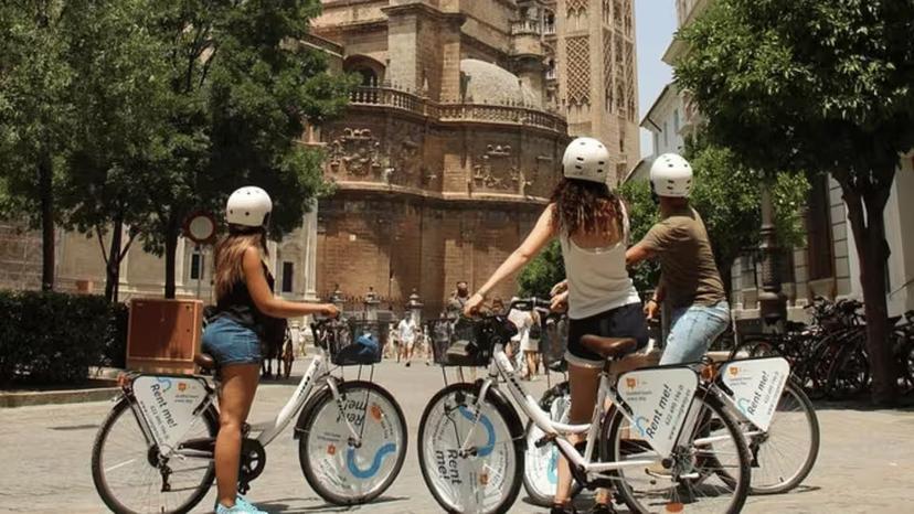 Cyclists admire the stunning architecture of Seville Cathedral on a guided bike tour.