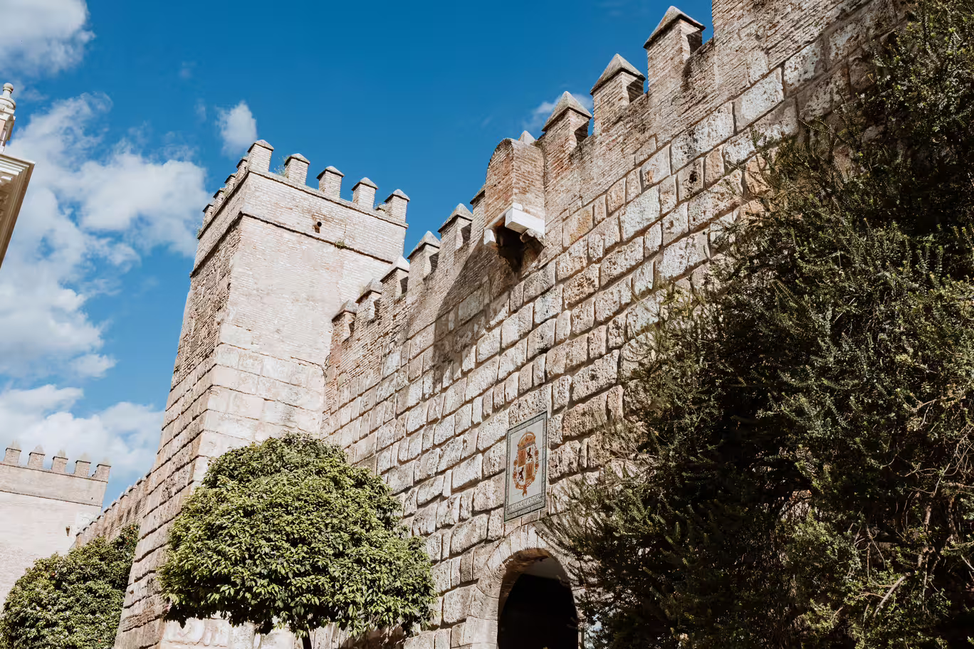 Historic stone walls under a blue sky in Seville's Santa Cruz, a highlight of the Jewish Quarter tour.