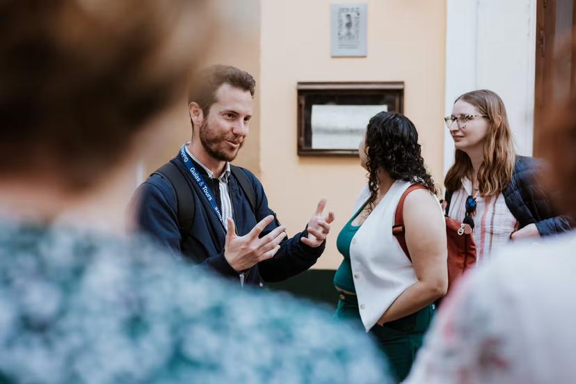 Engaged tour guide leading visitors through Seville's Santa Cruz neighborhood, sharing Jewish Quarter history.