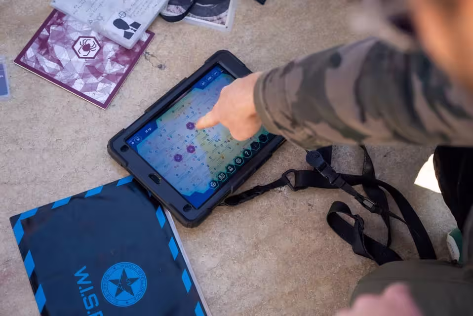 A player examines a digital map on a tablet during Seville's interactive escape game, Operation Mindfall.