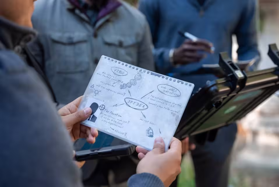 Team members analyze clues and notes for Seville's outdoor escape game, Operation Mindfall adventure.