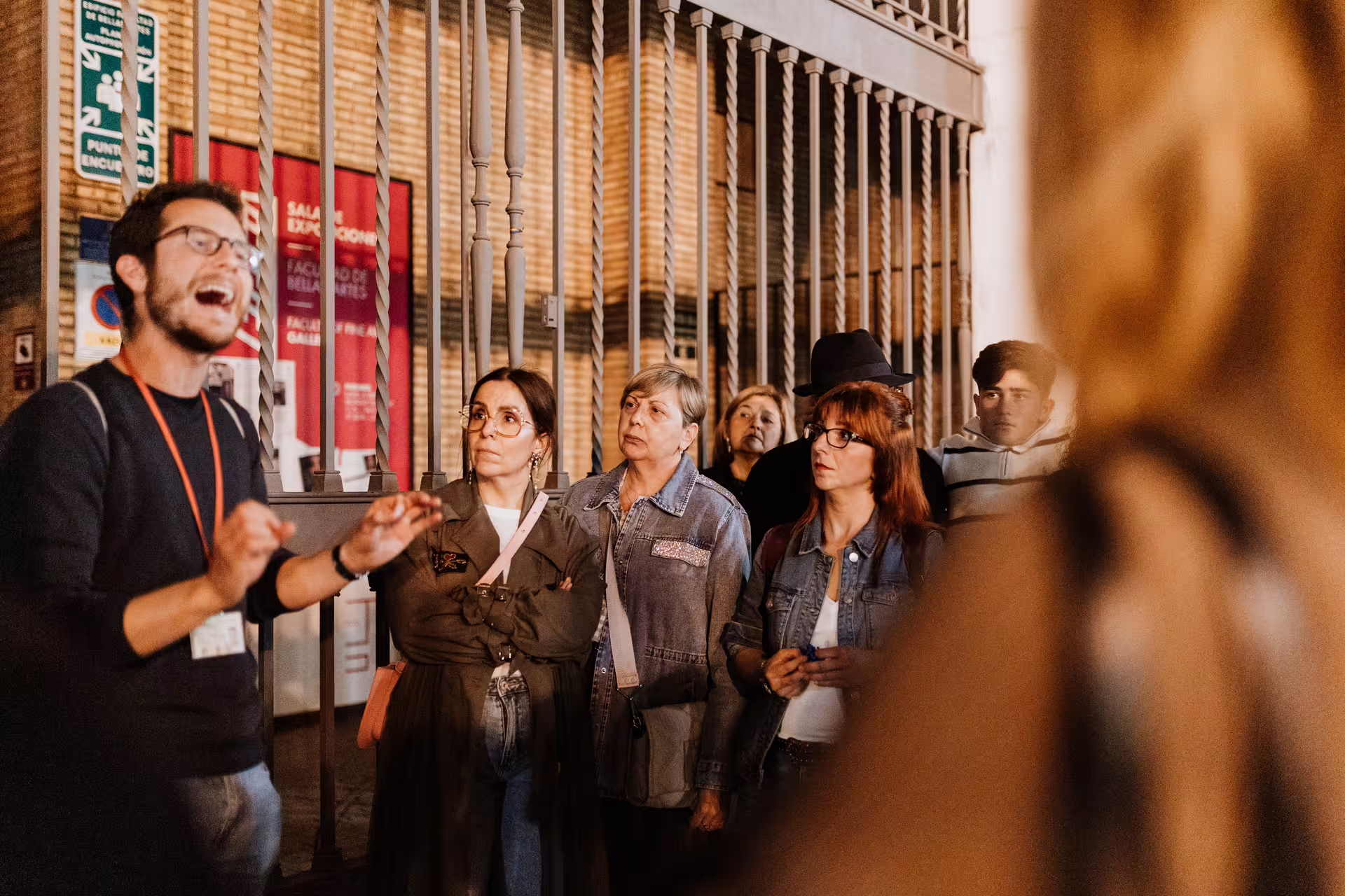 Tour guide engaging group on Seville Mysterious and Paranormal Tour at night, exploring the city's eerie and historic sites.