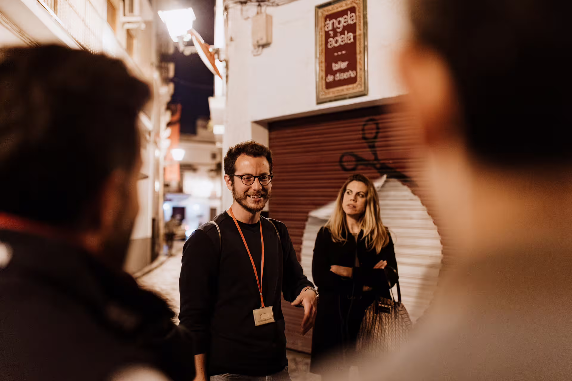 A nighttime guide leads a group through the eerie streets of Seville during the Mysterious and Paranormal Tour.