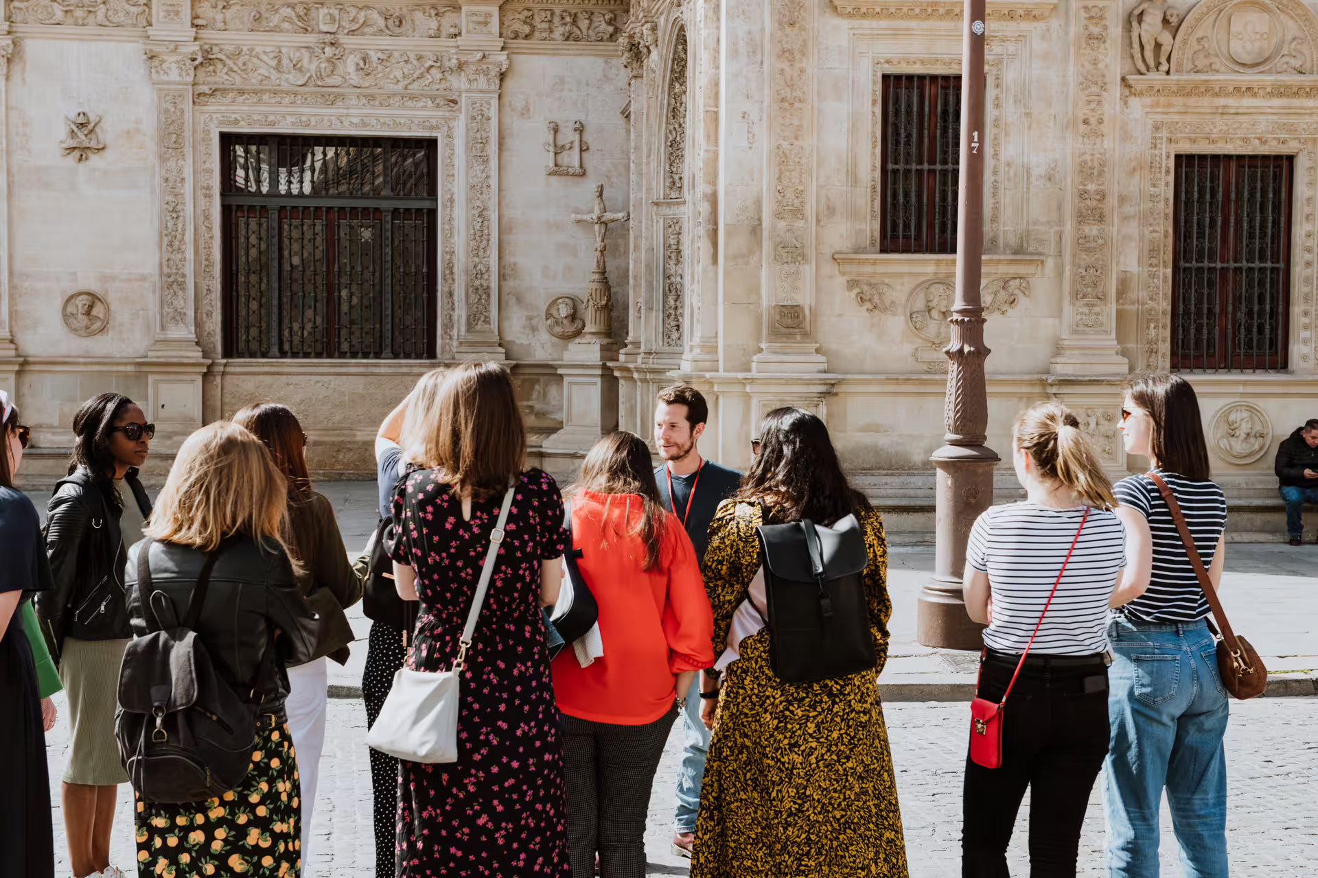 Tour group enjoying a private guided food tour in Seville, exploring local cuisine and historic architecture in the city center.