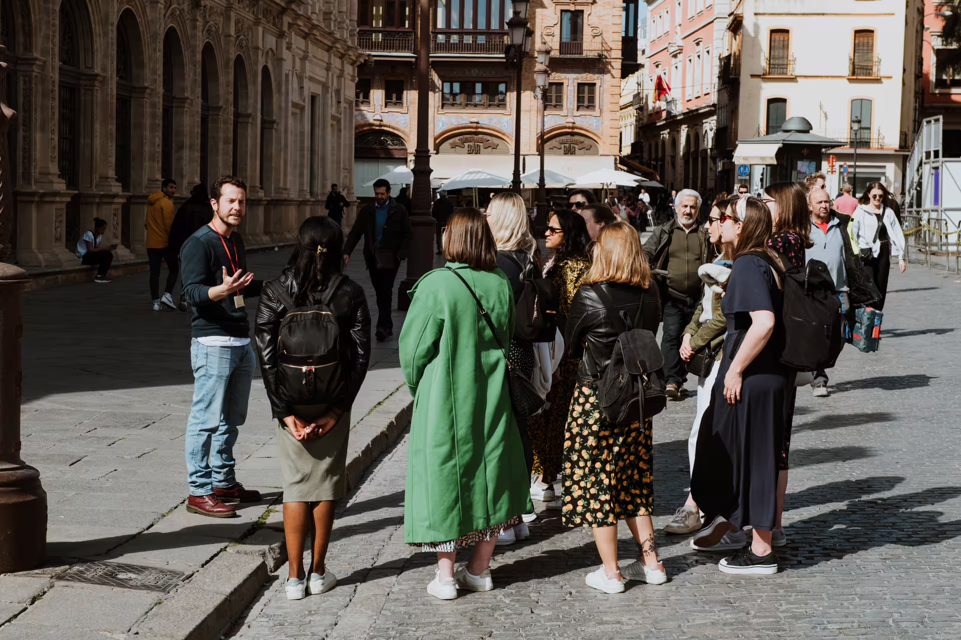 A guide leads a small group through the historic streets of Seville, showcasing the city's rich architectural heritage.